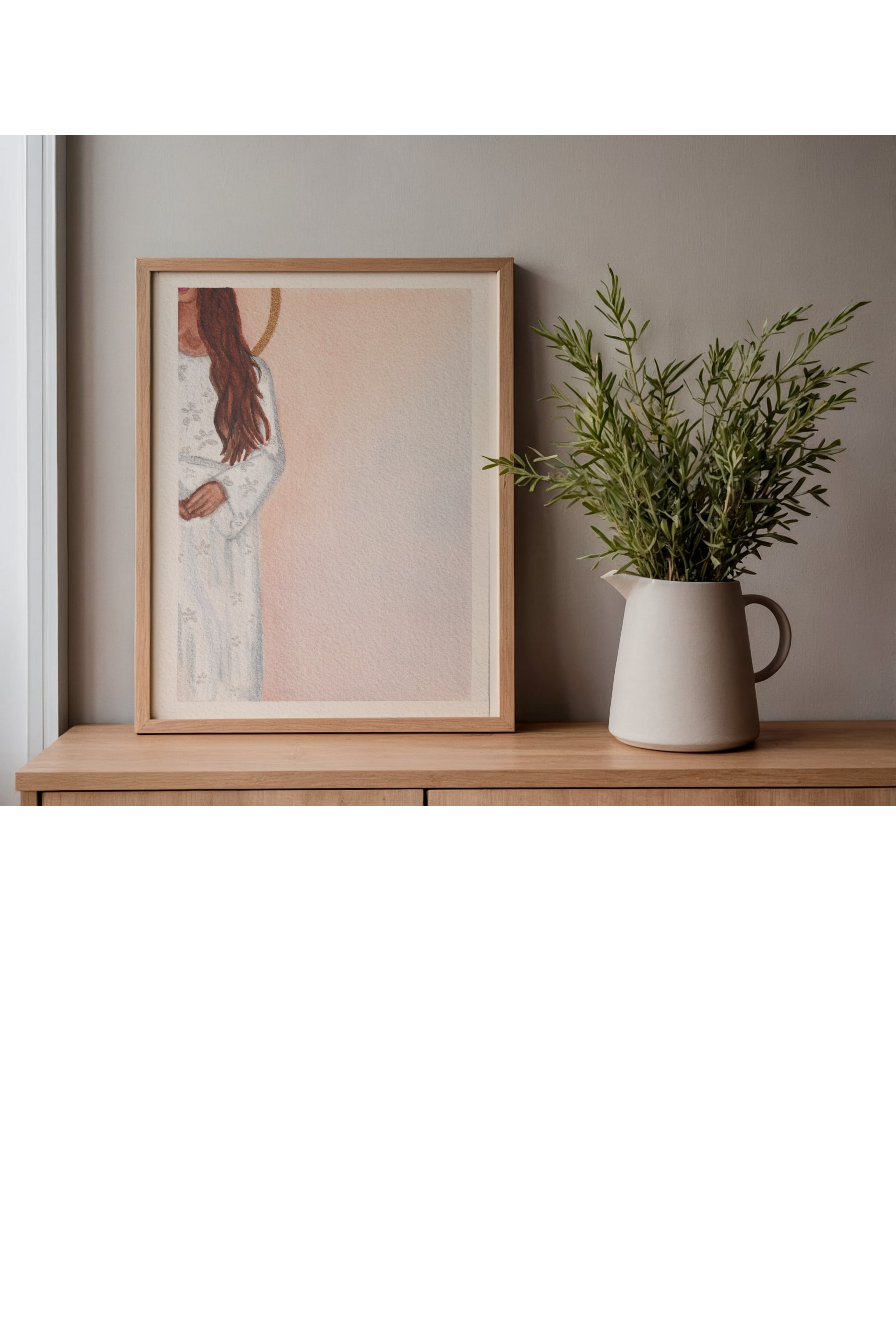 Framed artwork on a wooden shelf with a plant in a white vase.